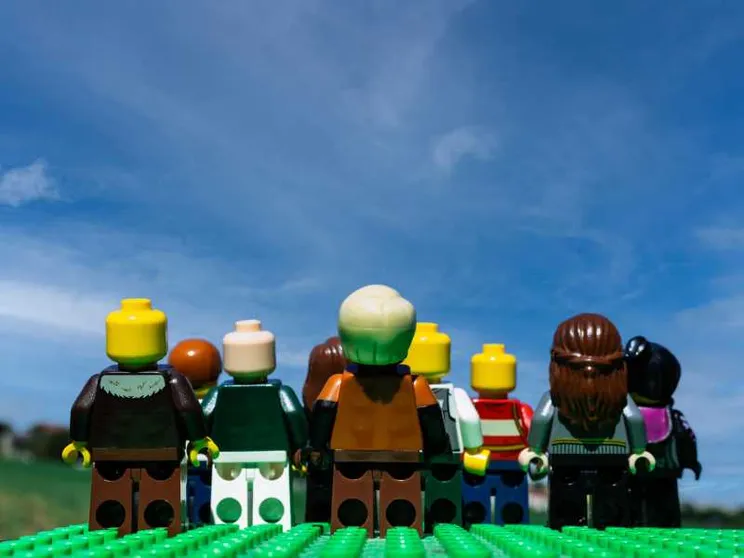 Nove omini Lego si muovono su un prato e guardano un cielo che diventa sempre più blu