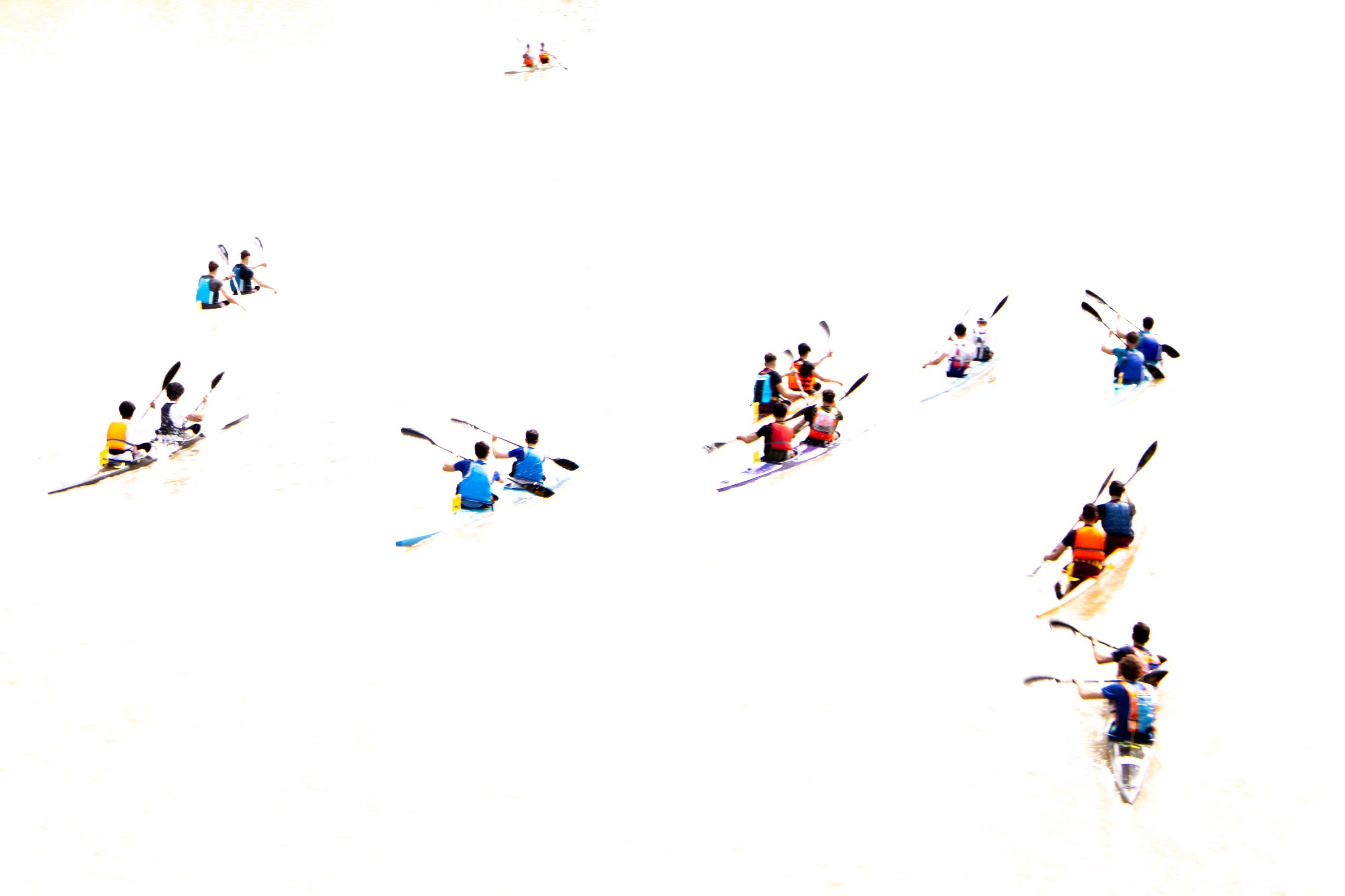 Ragazzi in canoa che si muovono in mare bianco per la luce abbagliante