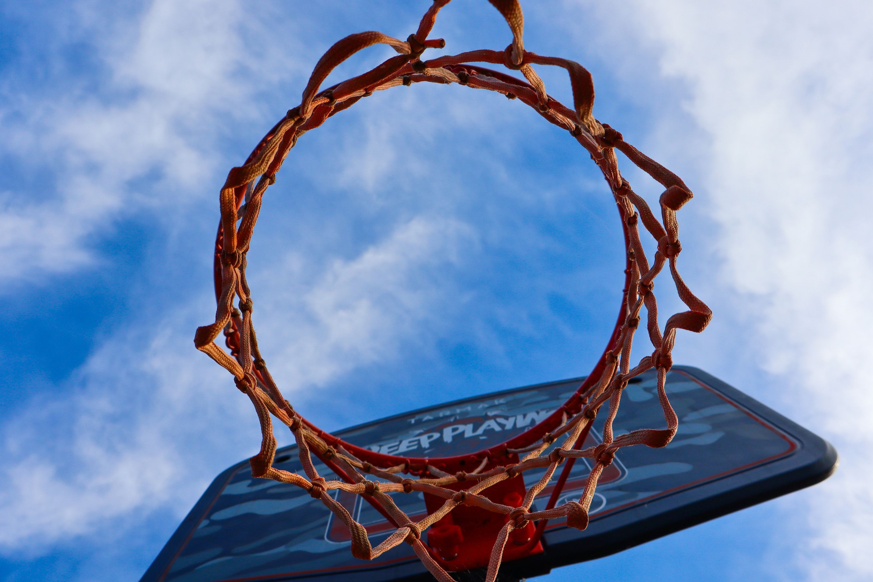 Un canestro ripreso dal basso, con il cielo sullo sfondo