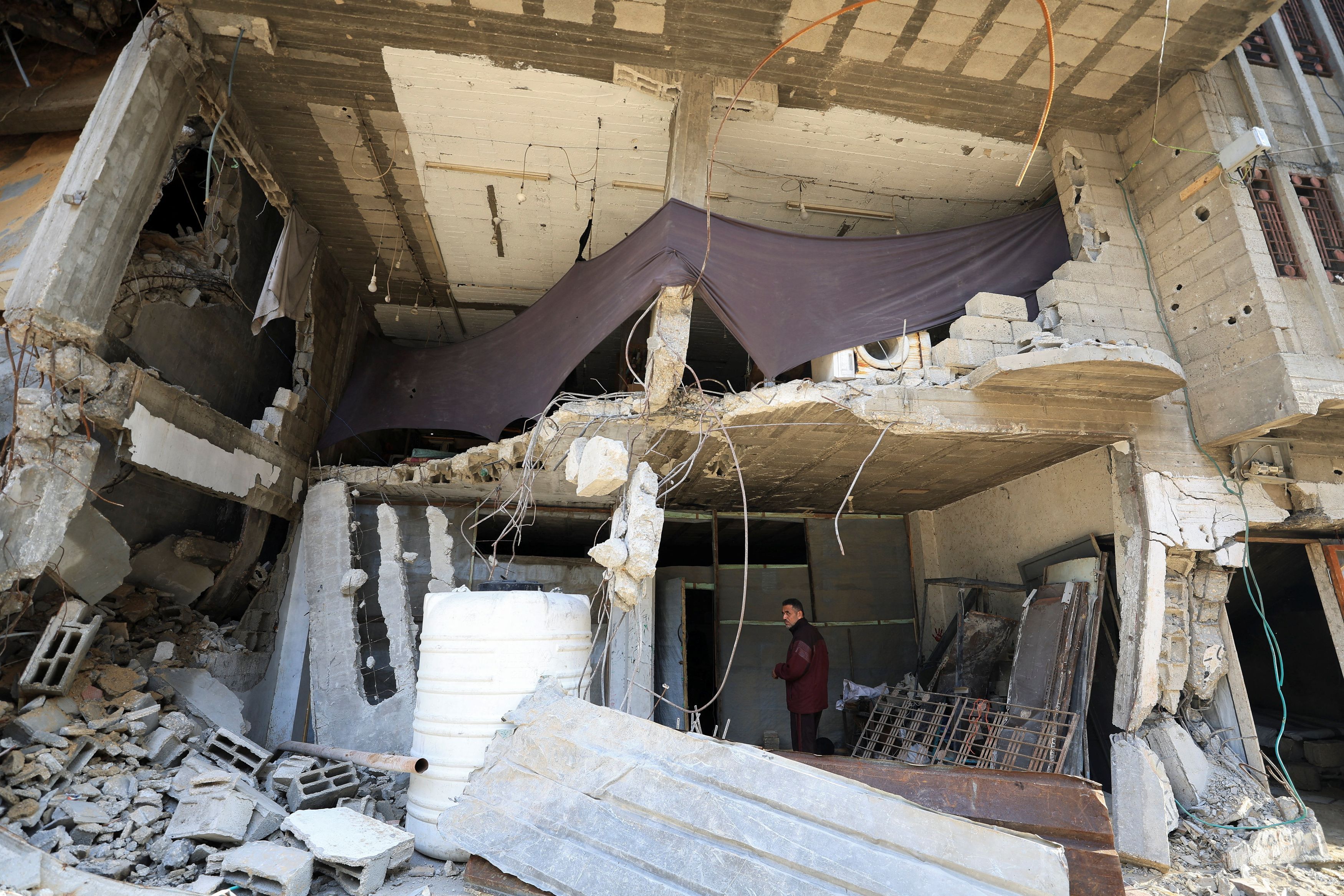 Qualcuno è riuscito ad allestire teloni nei piani bassi dei palazzi distrutti: gli oggetti sono stati risparmiati dalle piogge, ma il rischio, enorme, è che tutto possa crollare sotto il peso dell'acqua /Reuters