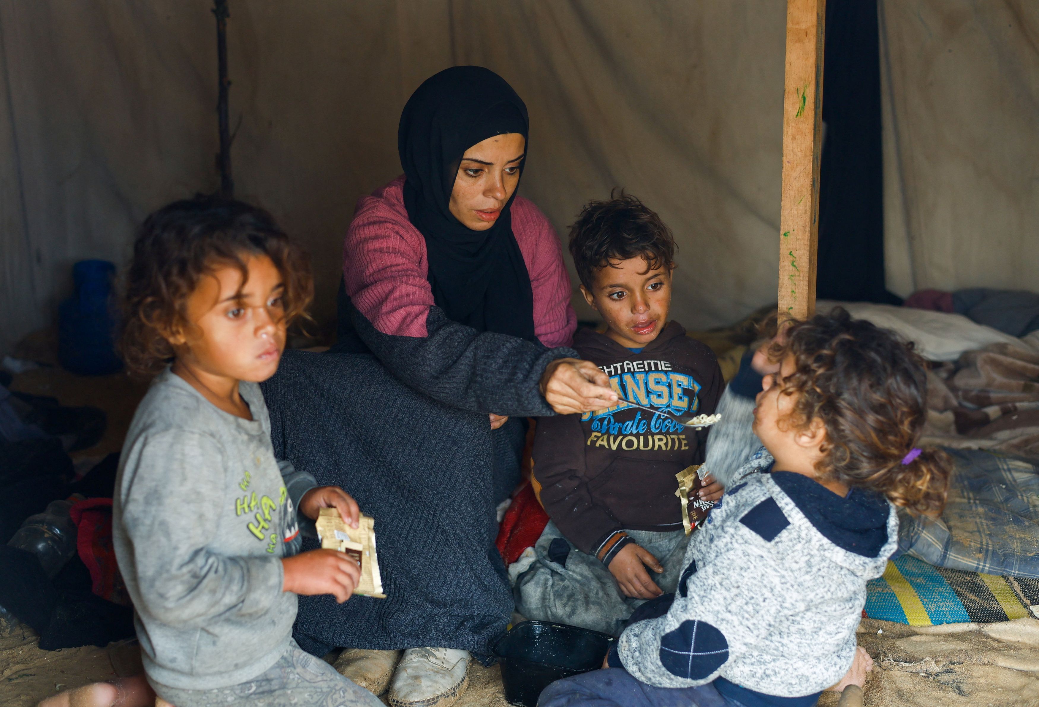 Una mamma con i suoi bambini nella loro tenda di Nuseirat, nella Striscia di Gaza centrale /Reuters