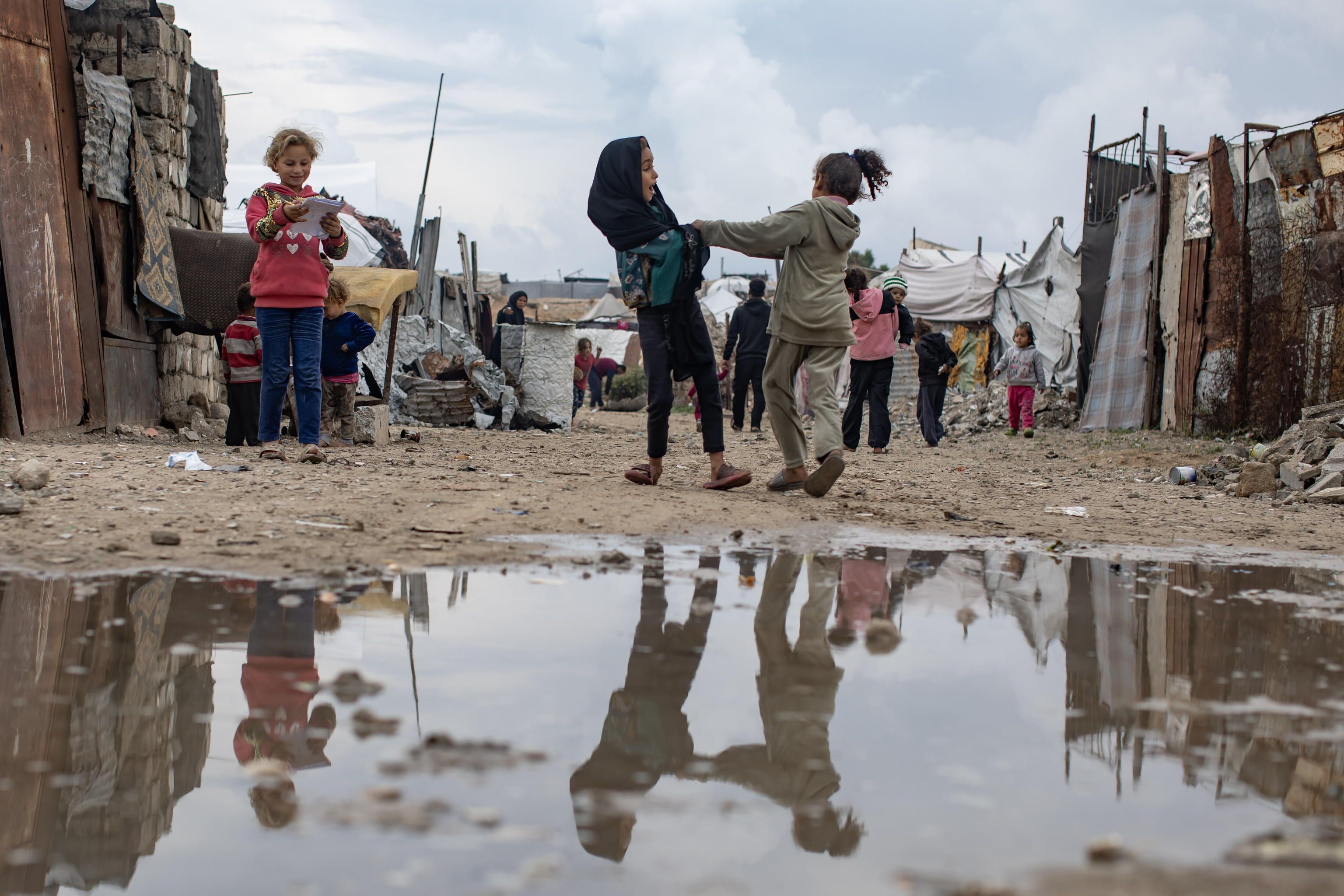 Bambini palestinesi sfollati davanti alle loro tende a Khan Yunis, nella Striscia di Gaza meridionale. Riescono a giocare, ma le loro condizioni sono estreme. E sono sempre più esposti a gravi infezioni, soprattutto a causa dell'acqua contaminata, e a malattie, aggravate dal freddo /Ansa