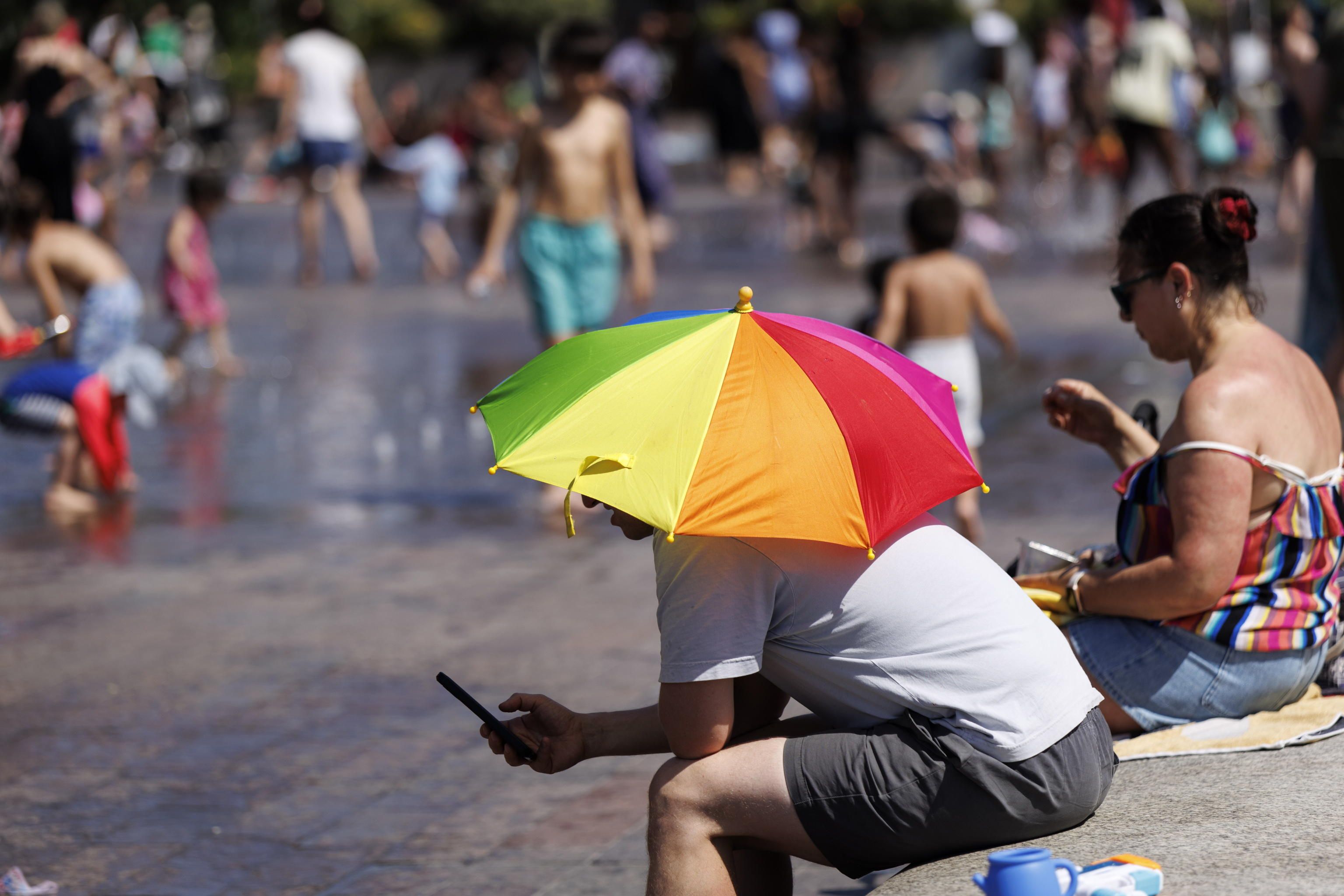 Una persona usa un ombrello per ripararsi dal sole a Granary Square, Londra. (Foto di TOLGA AKMEN /EPA)