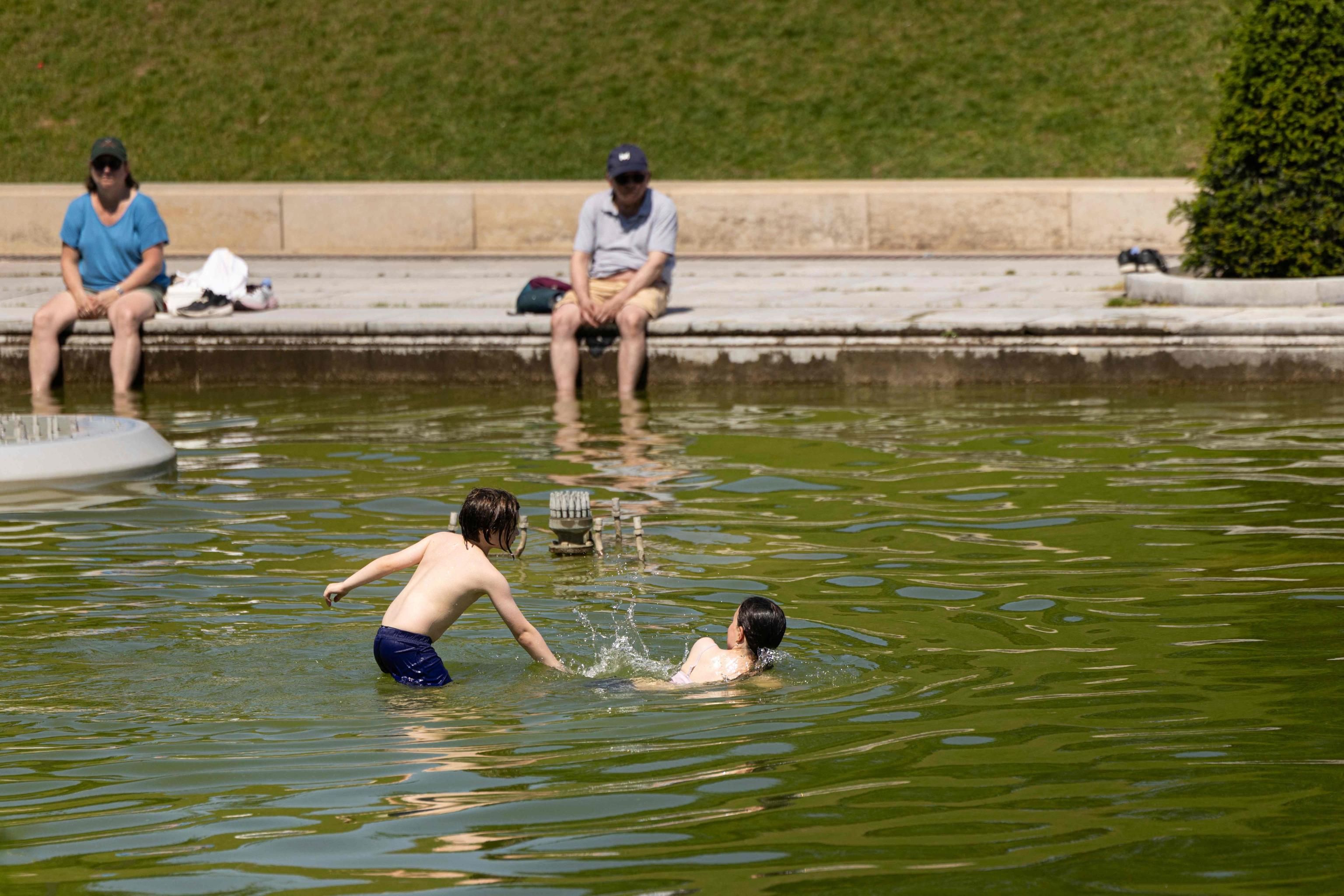 Dei bambini giocano in una vasca della Fontana del Trocadero, a Parigi  (Foto di JOEL SAGET / AFP)