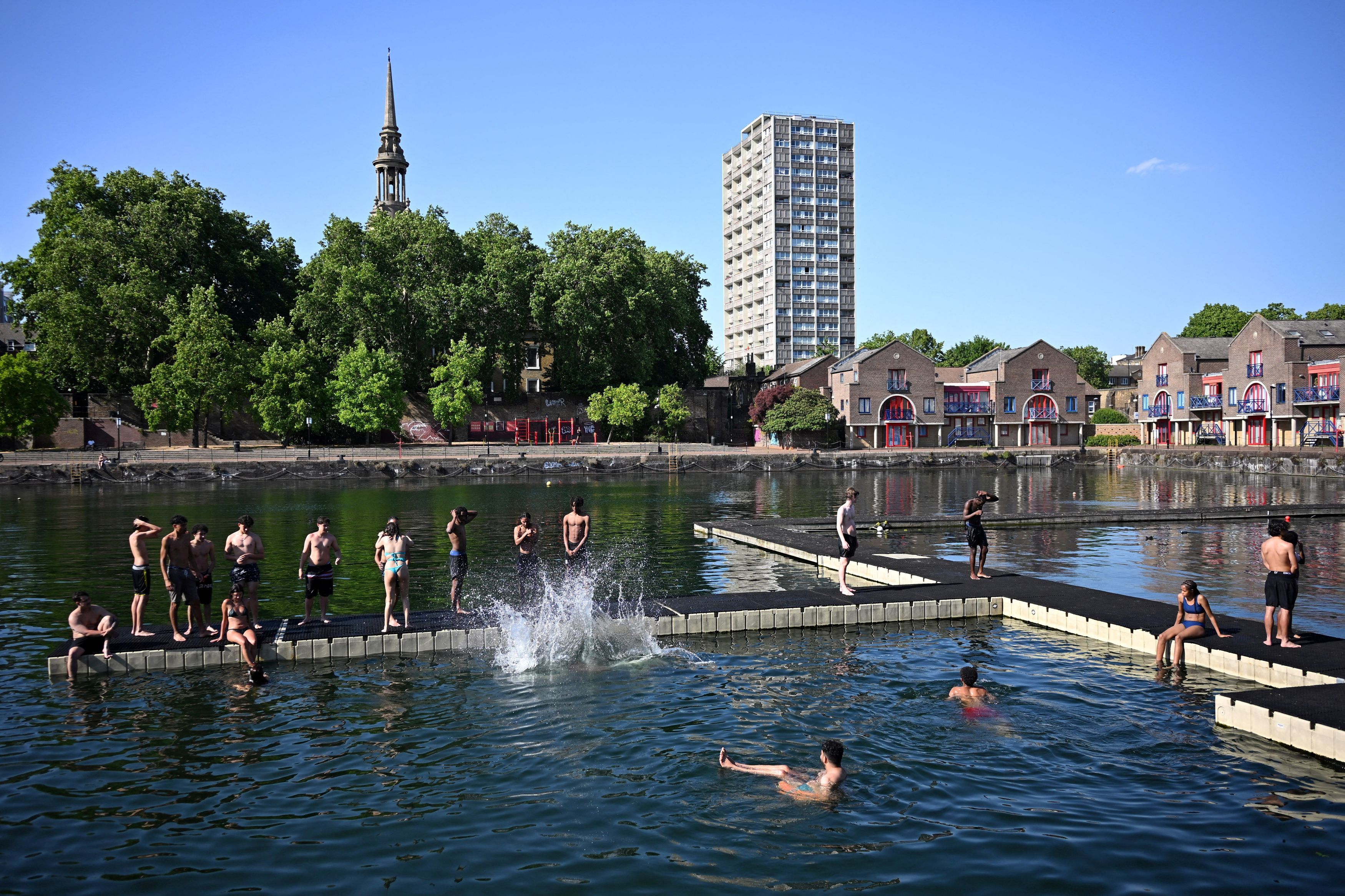 Alcuni ragazzi si rinfrescano mentre si rilassano su un molo nello Shadwell Basin di Londra. (Foto di DYLAN MARTINEZ /REUTERS)