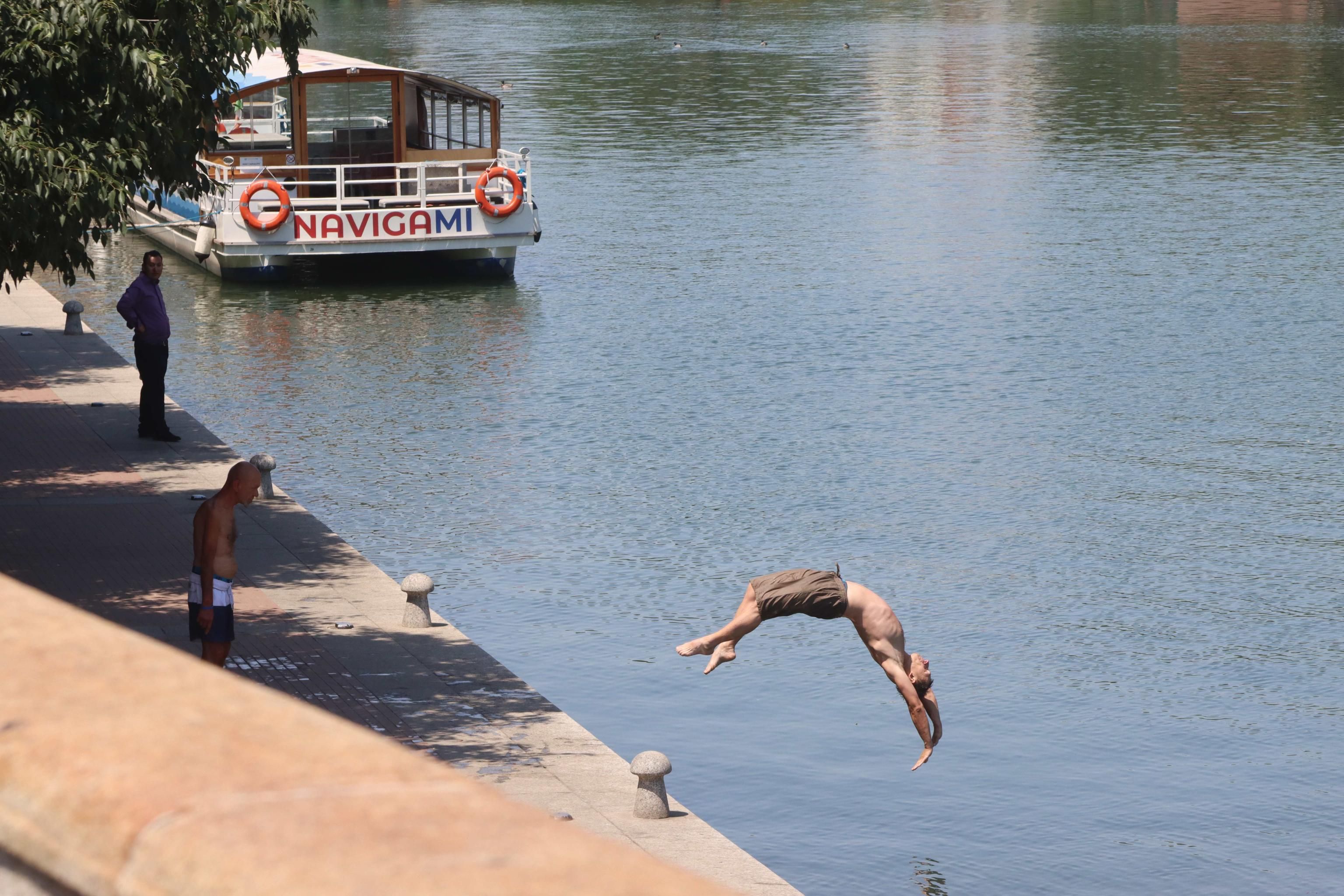 Una persona cerca refrigerio dal caldo tuffandosi nella Darsena a Milano, Italia. (Foto di PAOLO SALMOIRAGO /ANSA)