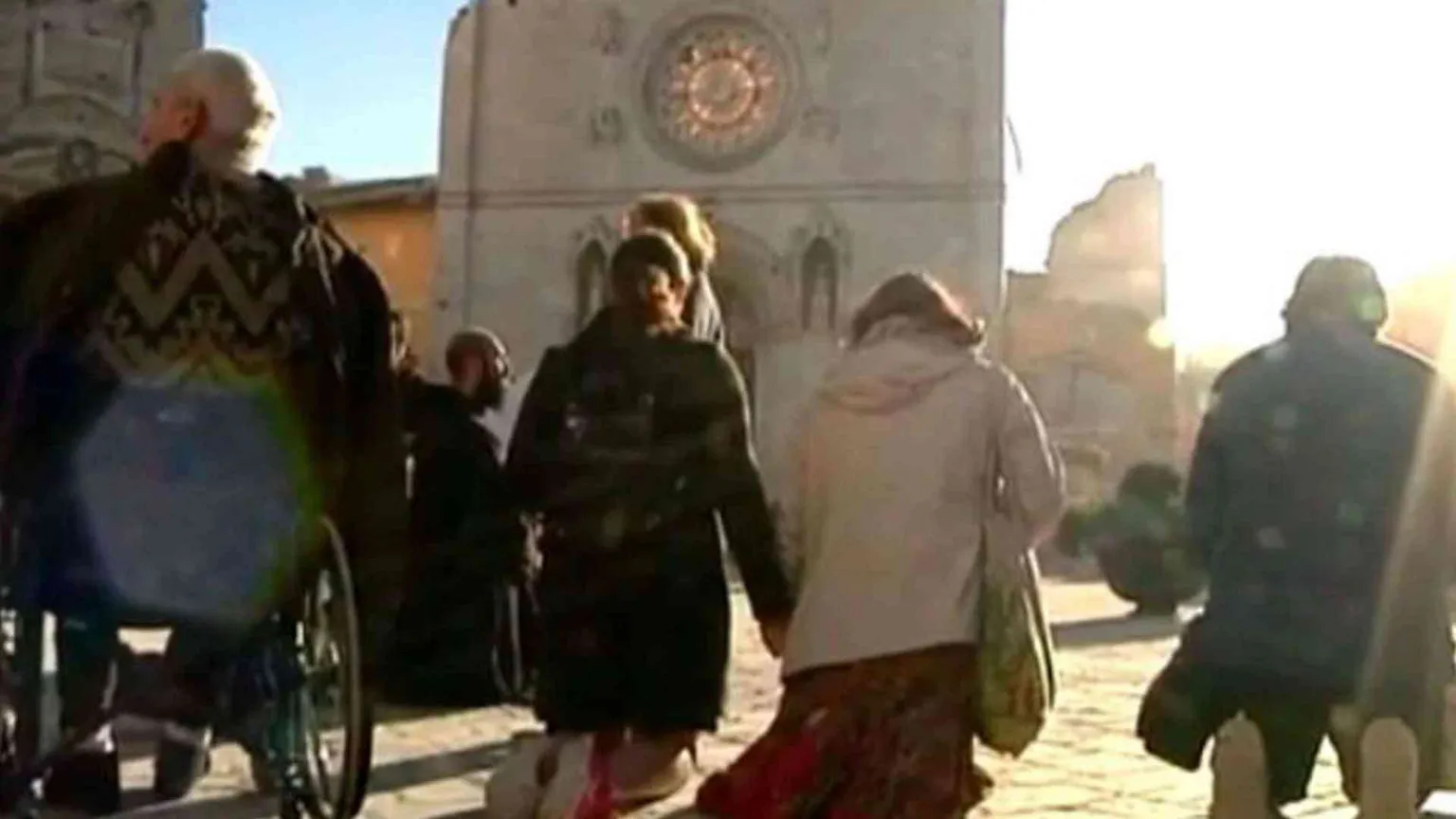In ginocchio di fronte alla basilica sventrata