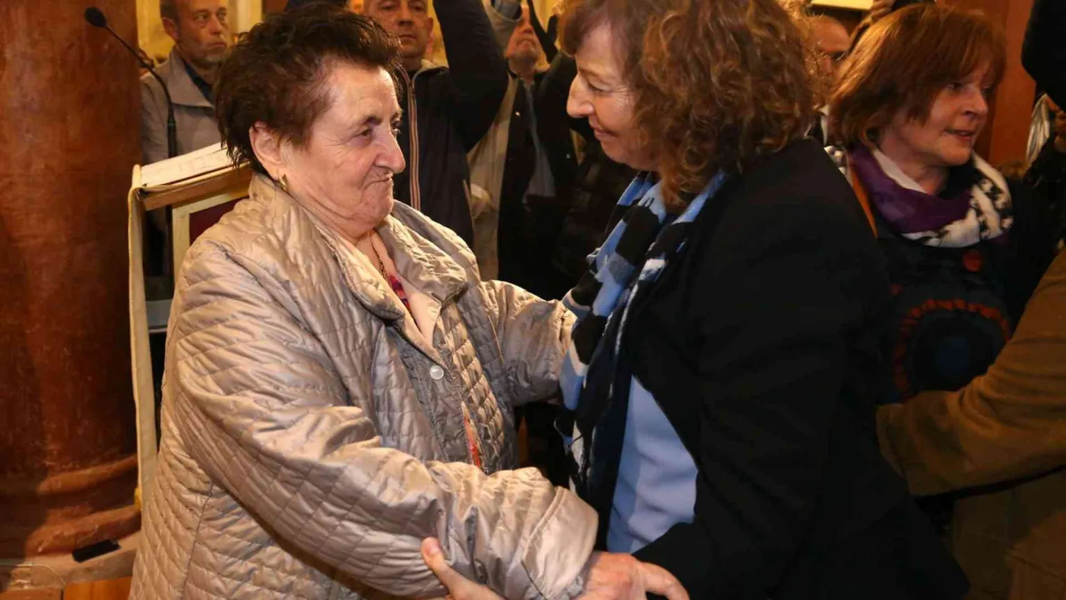 L'abbraccio fra i parenti del martire e la figlia del partigiano che lo uccise