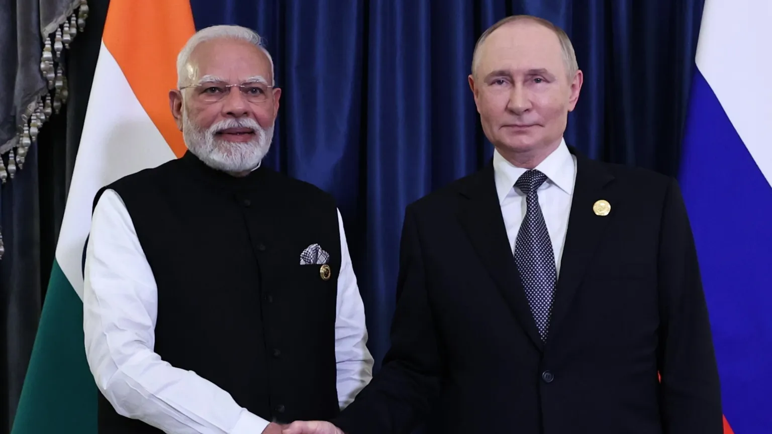 Il primo ministro indiano Narendra Modi (a sinistra) e il presidente russo Vladimir Putin si stringono la mano a margine del vertice dell'Organizzazione per la cooperazione di Shanghai in Cina