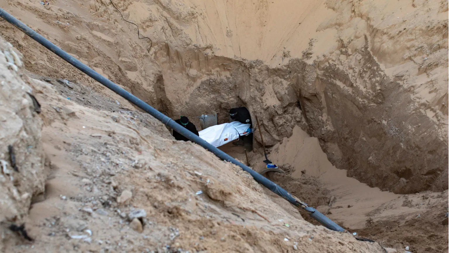 Miliziani di Hamas seppelliscono il corpo di un israeliano dopo averlo recuperato da un tunnel in Khan Yunis, nel sud di Gaza