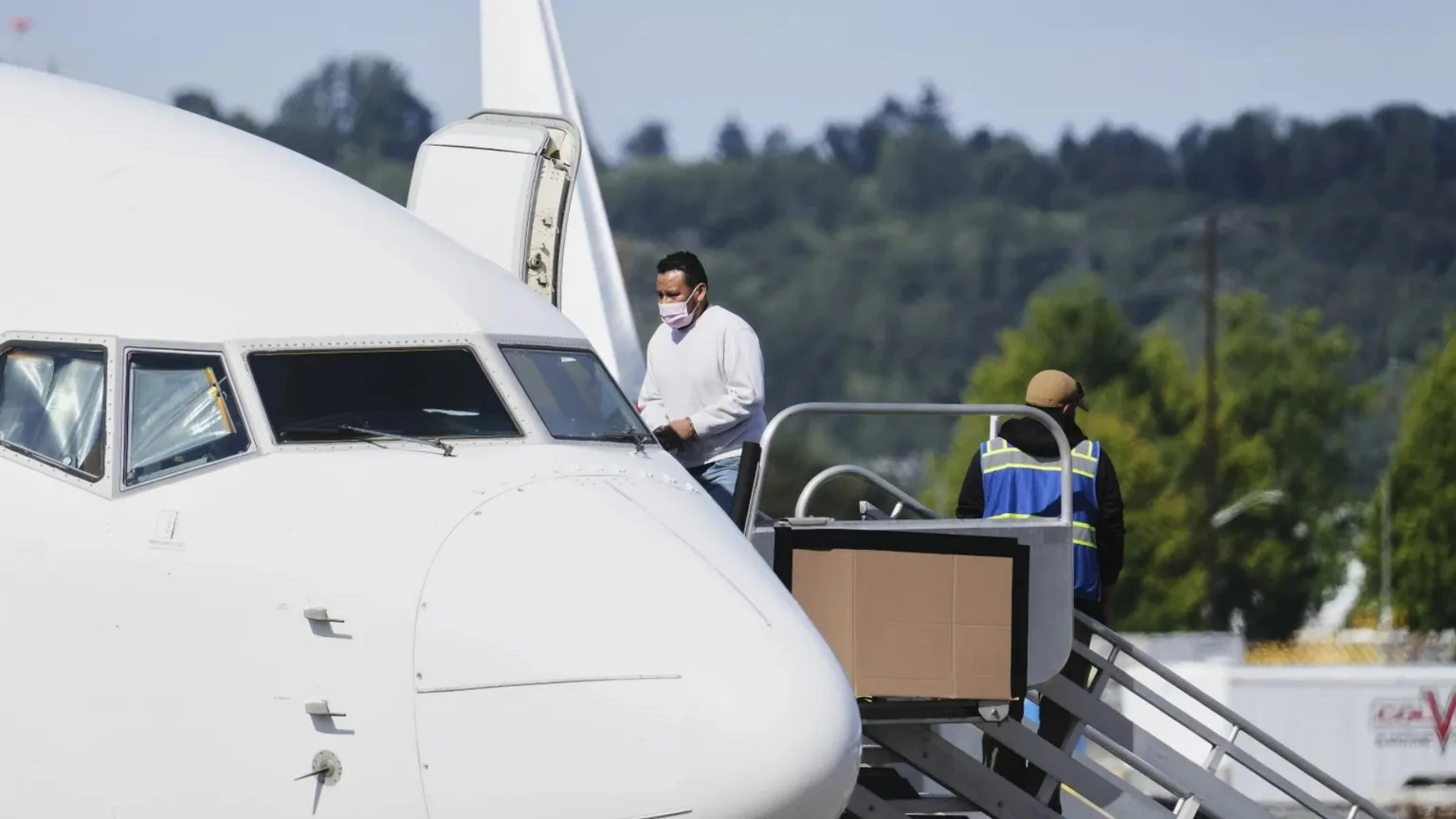 Un immigrato viene fatto salire a bordo dell’aereo che, dallo scalo di Alexandria, lo riporterà in patria dopo l’espulsione