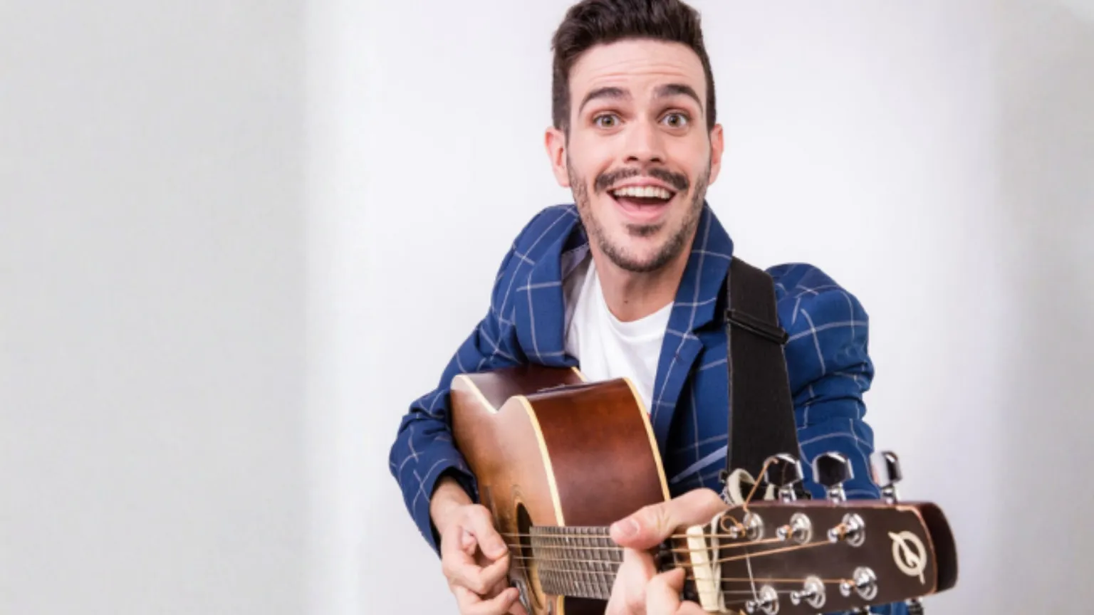 Lorenzo Baglioni, attore, ex-docente, conduttore televisivo, tiene in mano una radio rossa e nera, e sorride
