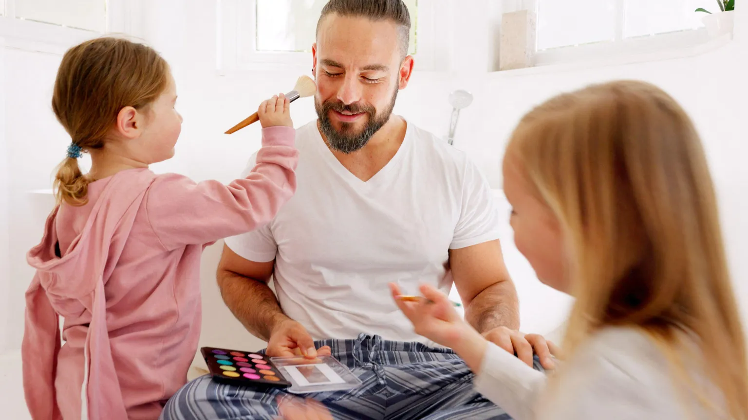 Due bimbe truccano il loro papà