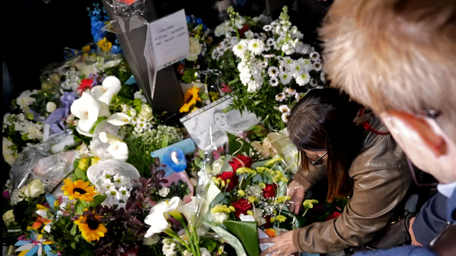 La mamma di Giacomo Bongiorni mentre depone dei fiori in memoria del figlio ucciso