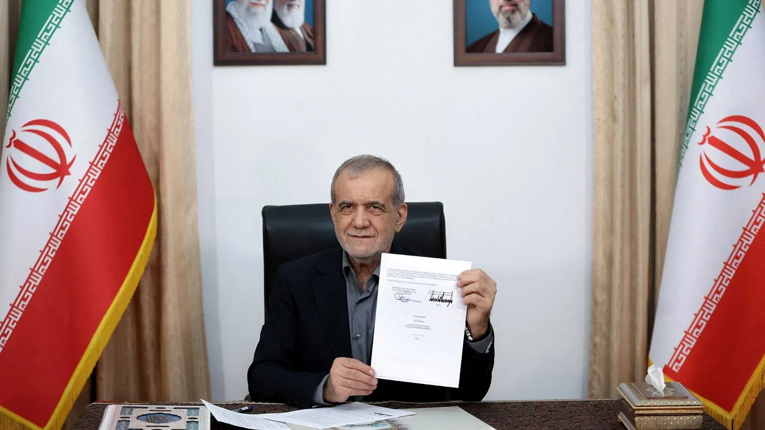 l presidente iraniano Masoud Pezeshkian mostra il documento del Memorandum d'intesa a Teheran