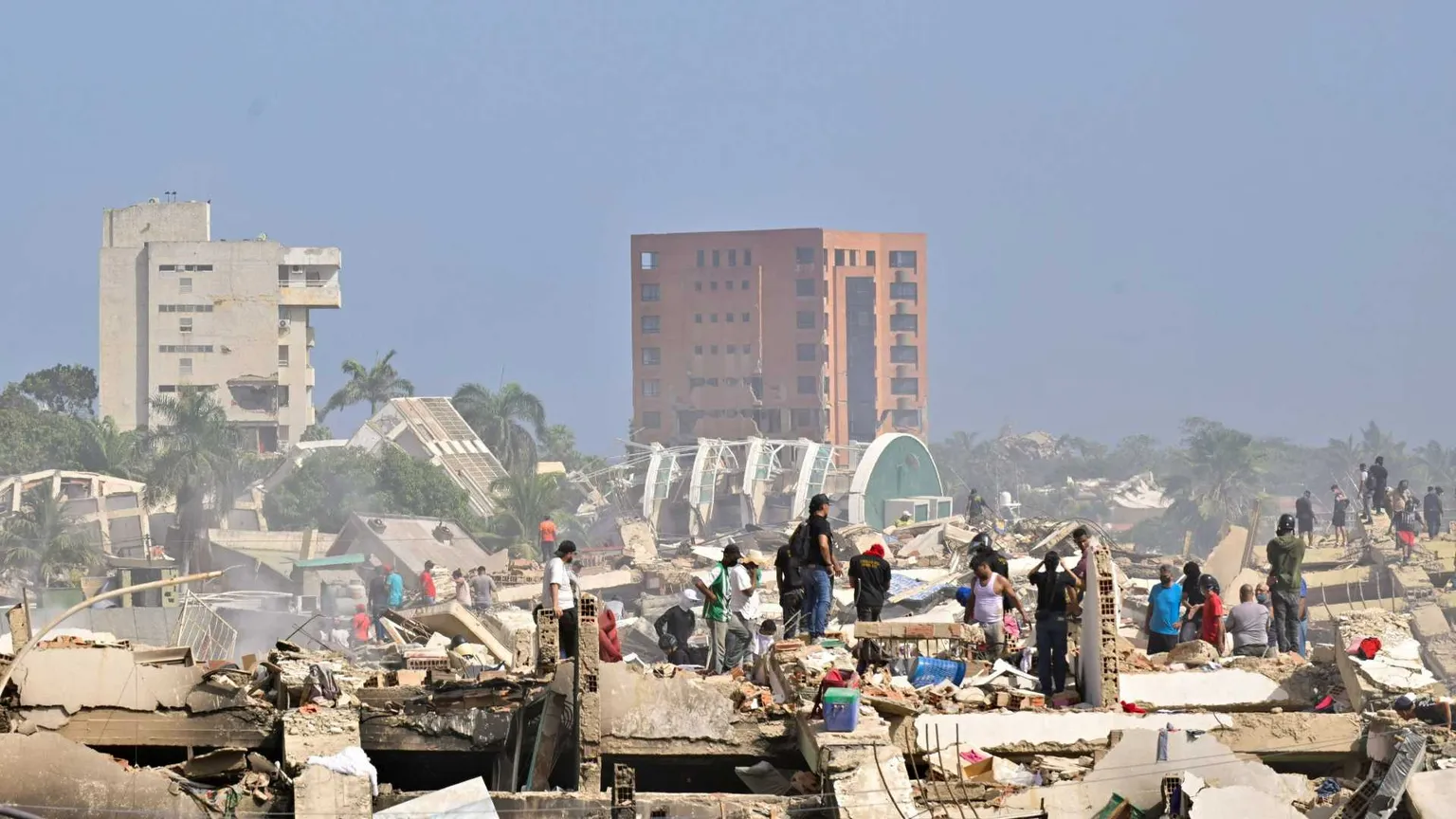 Decine di persone scavano tra le macerie a La Guaira, una delle località più colpite