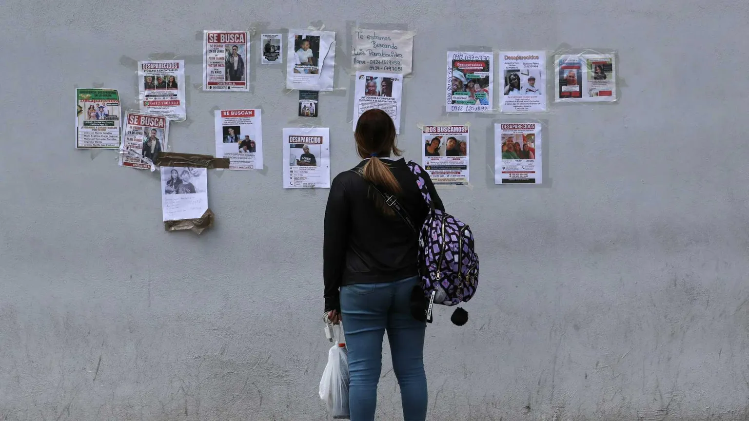 Una donna cerca i suoi familiari dispersi