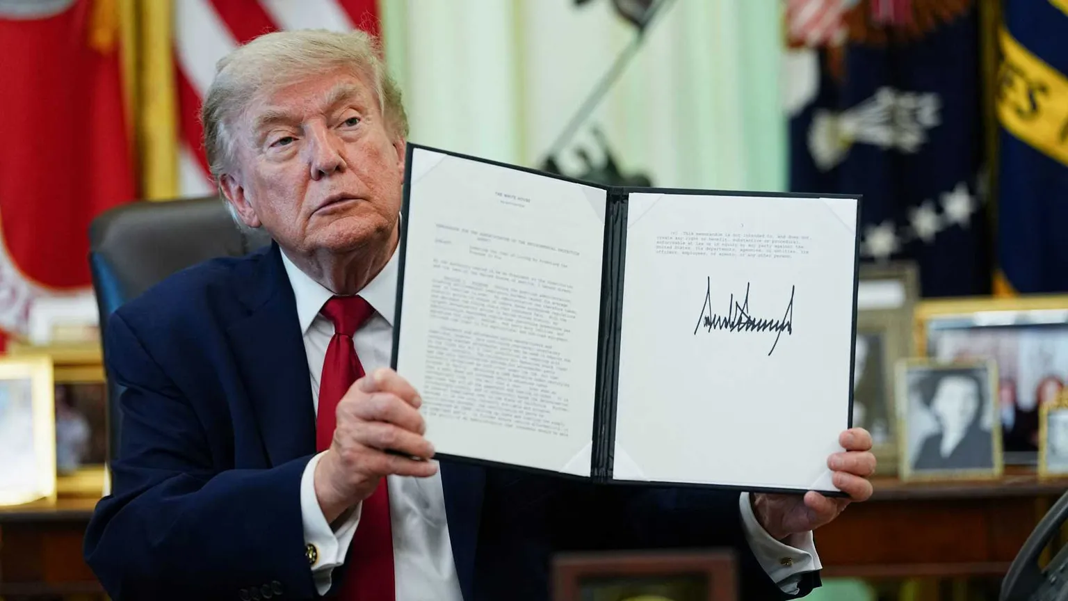 Donald Trump mostra uno dei suoi ordini esecutivi / REUTERS