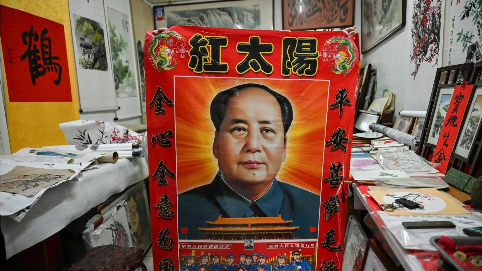Un venditore ambulante mostra un poster di Mao Zedong a Pechino