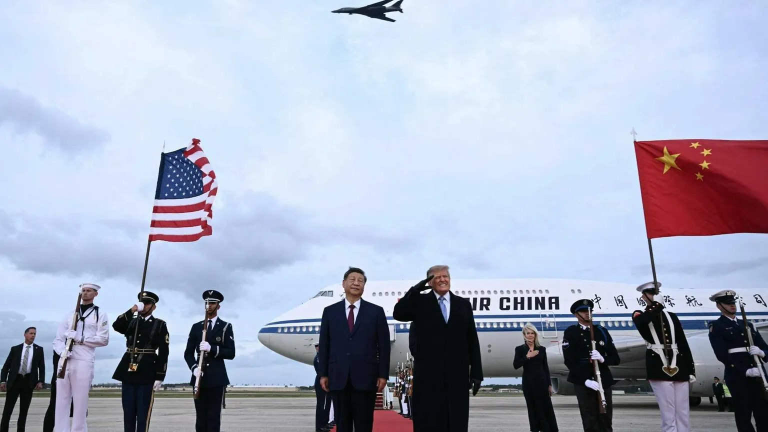 Il presidente degli Stati Uniti Donald Trump reagisce al passaggio di un bombardiere B-1 durante gli inni nazionali, mentre accoglie il presidente cinese Xi Jinping al suo arrivo alla Joint Base Andrews