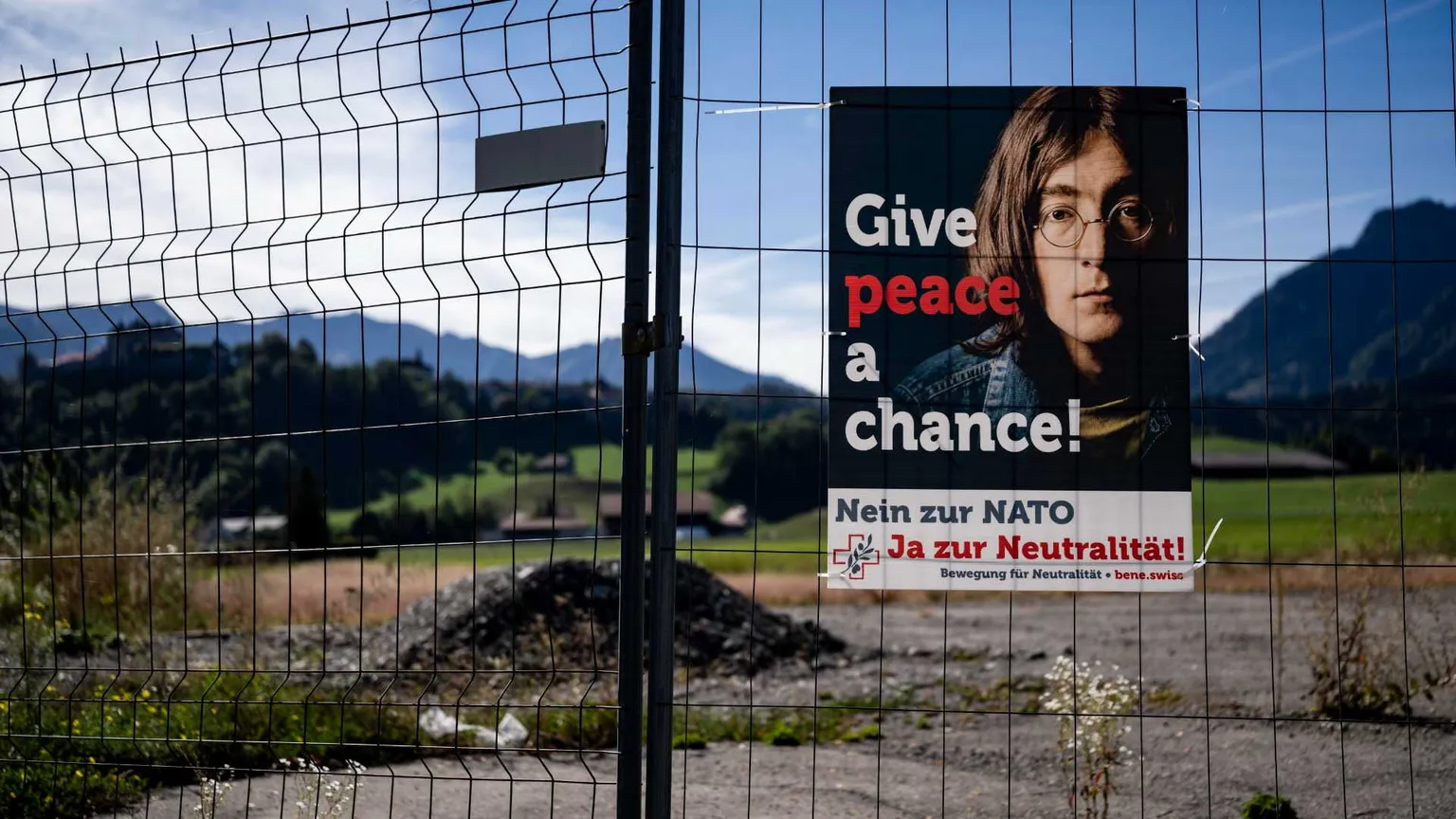 Una rete metallica, manifesto con foto di Lennon