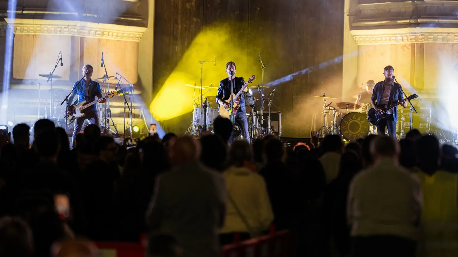 Una band musicale composta da quattro persone suona su un palco davanti al pubblico
