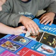 Prete rilancia l'album di figurine dei santi