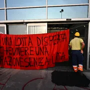 Un operaio con uno striscione protesta per la sicurezza sul lavoro