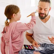Due bimbe truccano il loro papà