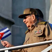 Un uomo si sporge da un parapetto con una bandiera cubana in mano. Si tratta di Raul Castro, ex presidente cubano