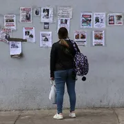 Una donna cerca i suoi familiari dispersi