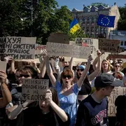 Gente in piazza a Kiev con cartelli scritti in ucraino di protesta per il licenziamento di Fedorov