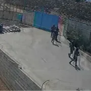 Soldati che fanno irruzione dentro a un cancello. Visti da lontano