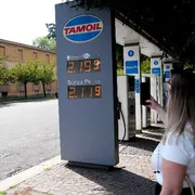 Una signora fotografa i prezzi del caro carburante