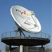 Una grande parabola televisiva bianca puntata verso il cielo