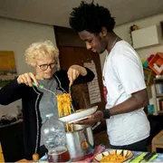 Mamajang dal Gambia con la nonna Maria, a Palermo, mentre servono in tavola la pastasciutta preparata insieme / UNICEF