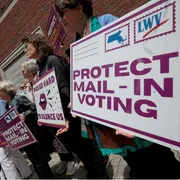 Persone protestato con dei cartelli su cui è scritto: protect mail - in voting