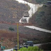 Una strada in terra battuta su cui passano due carroarmati
