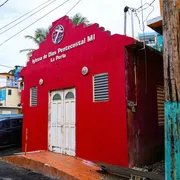 Una chiesa rossa in un quartiere con case colorate