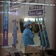 Una dipendente al lavoro presso lo stabilimento Jabil che produce PCB (circuiti stampati) e altri componenti elettronici, a Wuxi, in Cina