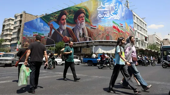 Persone camminano per le strade di Teheran. Sullo sfondo, gli ayatollah Khomeini e Khamenei