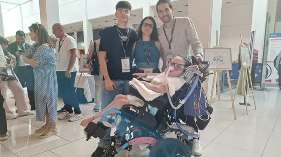 La famiglia Sciarretta con Noemi in carrozzina davanti alla mostra dei suoi quadri a ExpoAid a Rimini / foto Riccardi