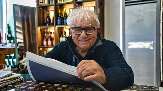 Una delle fotografie più recenti di don Mazzi, in mano un quotidiano