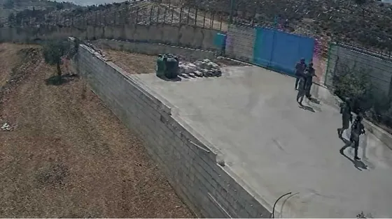 Soldati che fanno irruzione dentro a un cancello. Visti da lontano