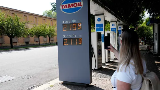 Una signora fotografa i prezzi del caro carburante