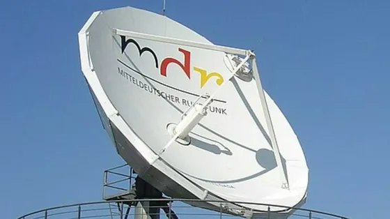 Una grande parabola televisiva bianca puntata verso il cielo