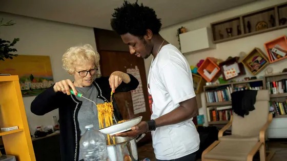 Mamajang dal Gambia con la nonna Maria, a Palermo, mentre servono in tavola la pastasciutta preparata insieme / UNICEF