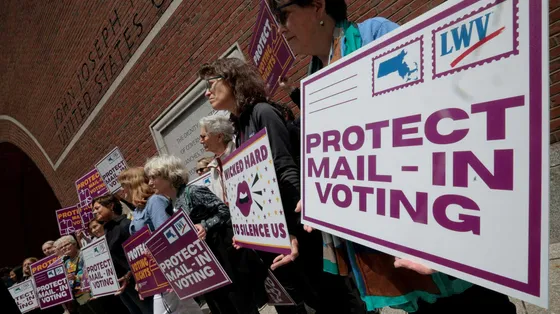 Persone protestato con dei cartelli su cui è scritto: protect mail - in voting