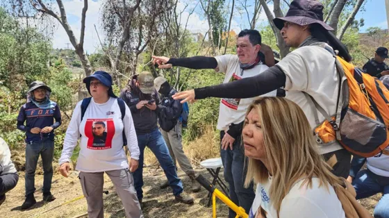 Familiari cercano in uno sterrato alla periferia di Guadalajara. Indossano magliette bianche con le foto dei parenti scomparsi