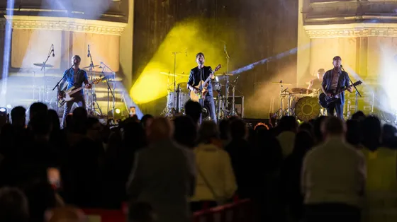 Una band musicale composta da quattro persone suona su un palco davanti al pubblico
